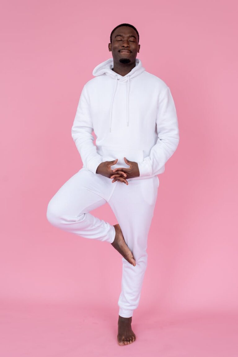 smiling black man balancing on leg in studio